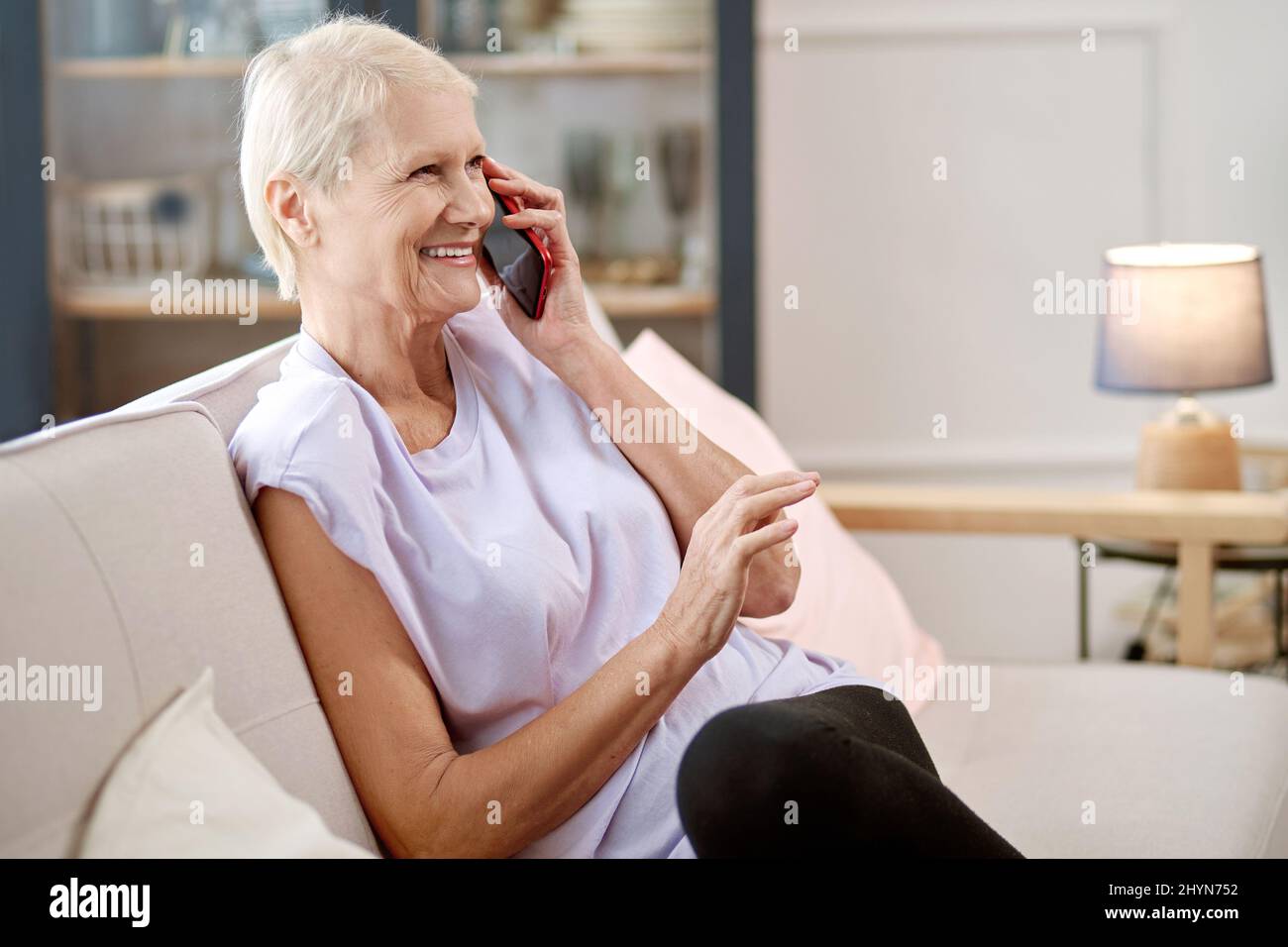 elderly woman sitting in a yoga pose in front of an open laptop Stock ...