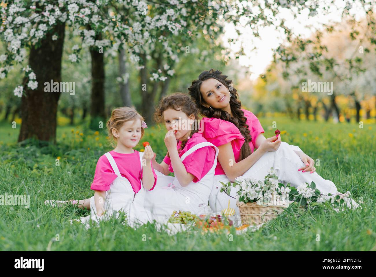 A beautiful mother and two daughters in bright clothes are having a