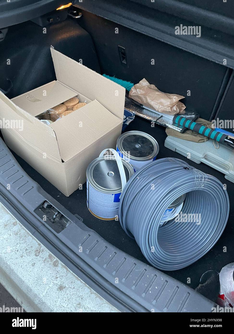 Opened car trunk with packages of food, paint and cable roll for Ukrainian army. Gratuitous support of Ukrainian army by volunteers and people. War in Stock Photo