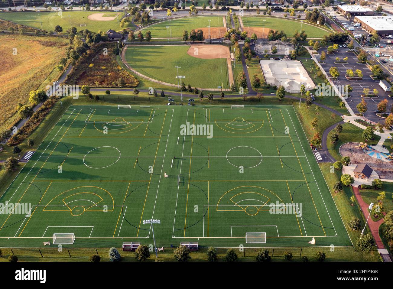 Aerial view of a sports complex with baseball/softball diamonds, artificial turf soccer and lacrosse field, a skate park and batting cages. Stock Photo