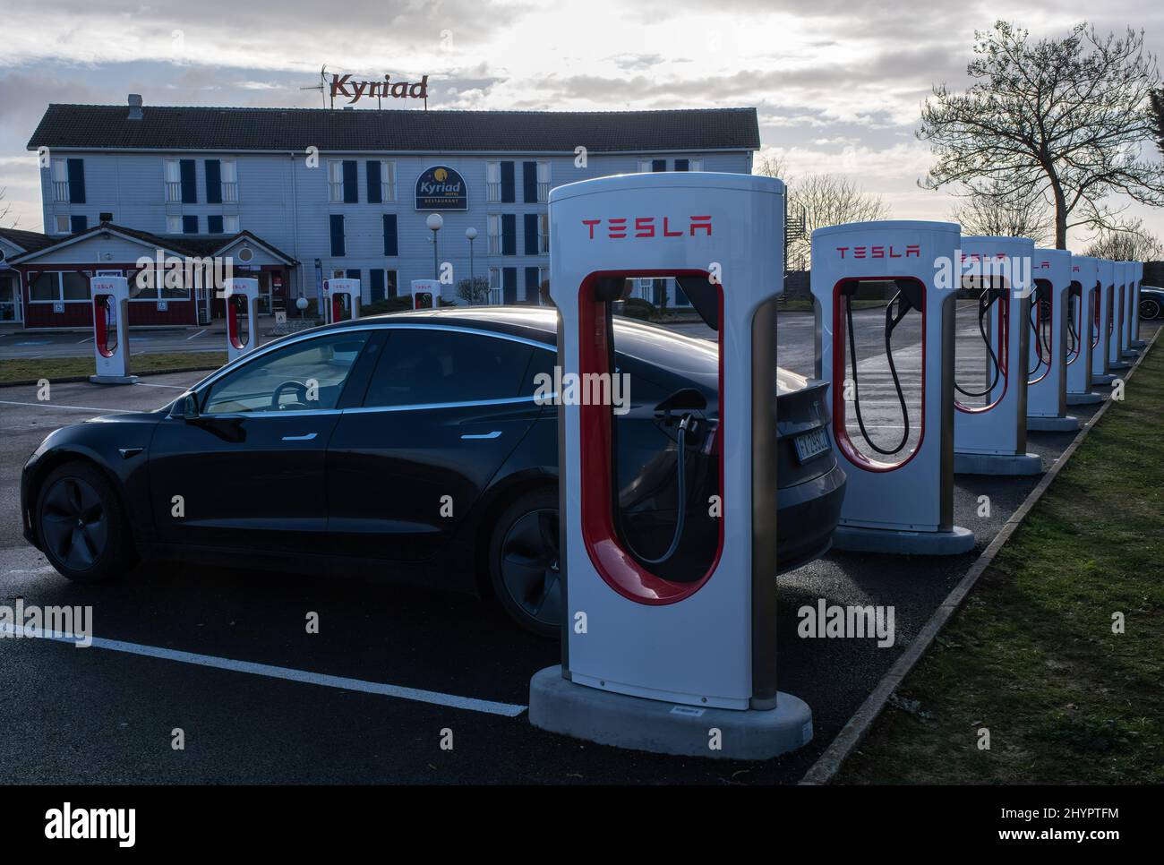 Longvic, France - February 21 , 2022: A static shot of a solid black Tesla Model 3 dual motor long range awd charging at the Kyriad Hotel Supercharger Stock Photo