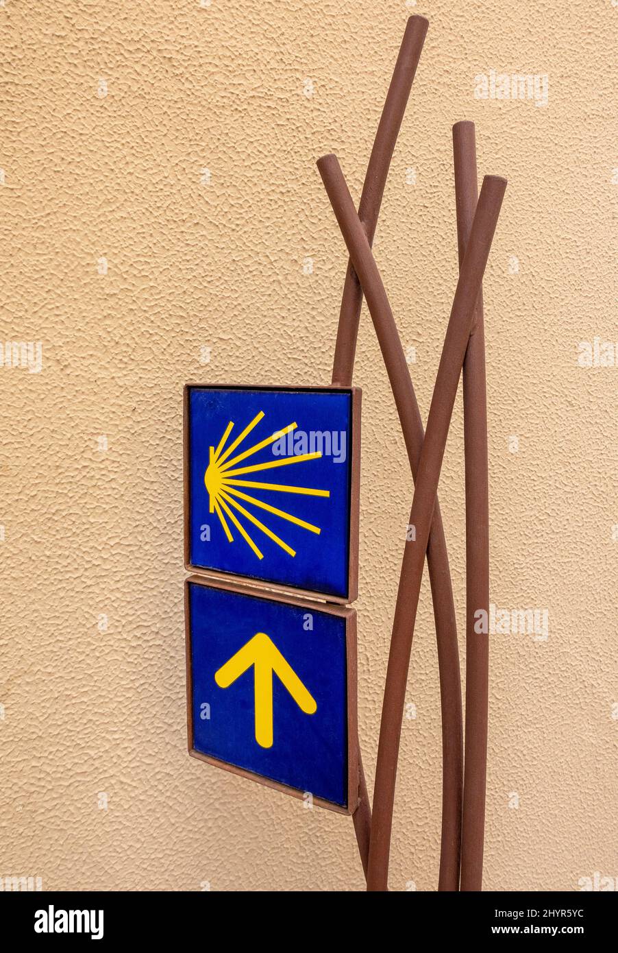 Modern yellow arrows and shell symbol directing pilgrims on the Camino De Santiago in northern Spain Stock Photo