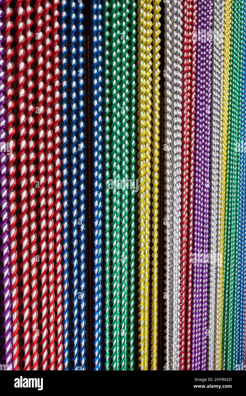 Colourful beaded door curtains perfect for keeping out flys and providing shade to a sunny doorway Stock Photo