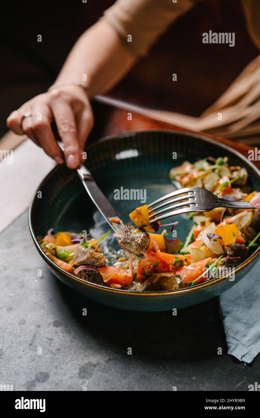 salad with stewed veal cheeks, potato wedges, tomatoes and mustard