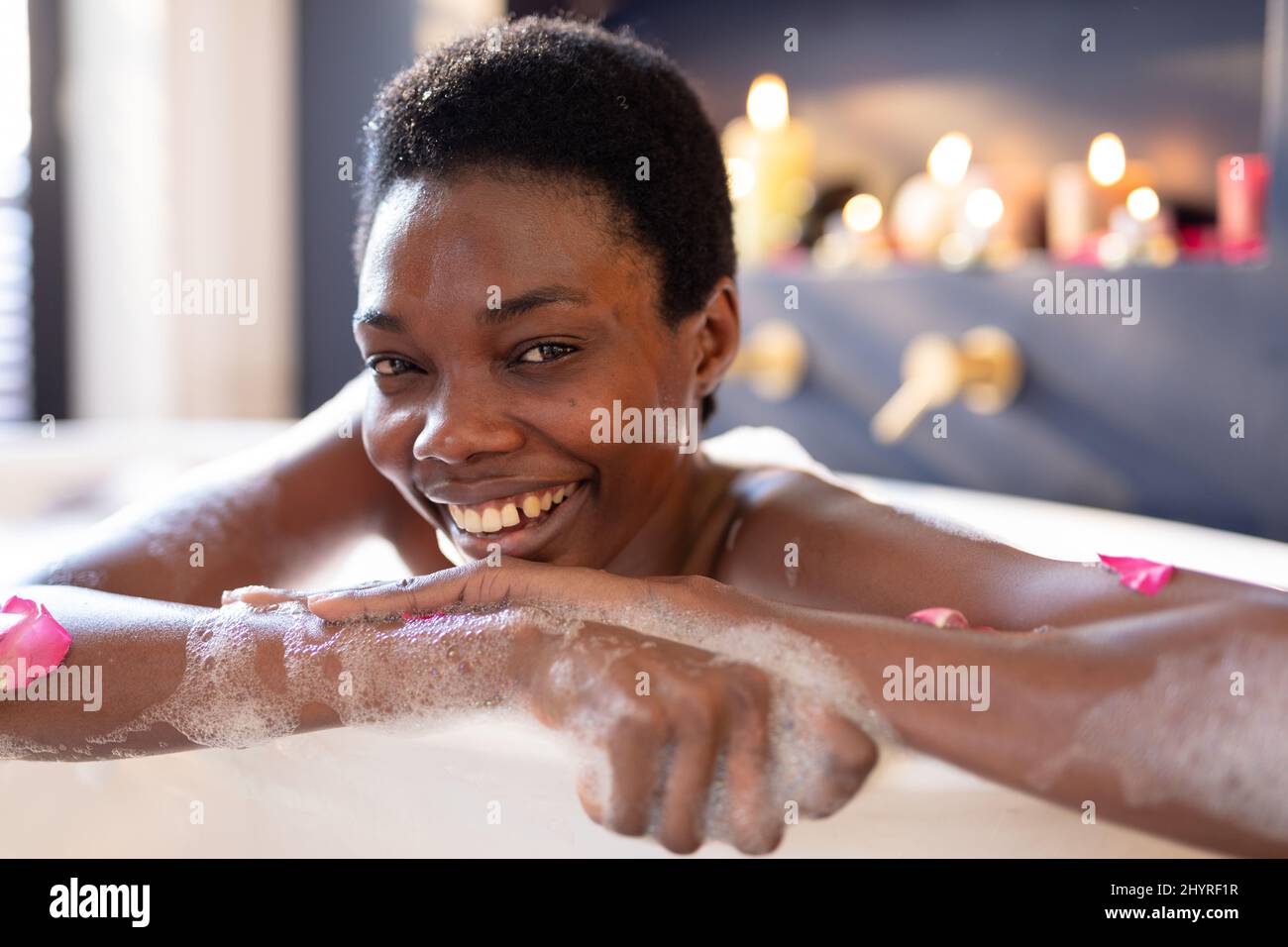 Portrait of smiling african american young woman enjoying bathing in ...