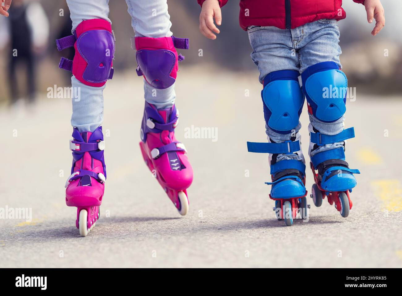 Kids boy and girl having fun outdoor while riding roller skates