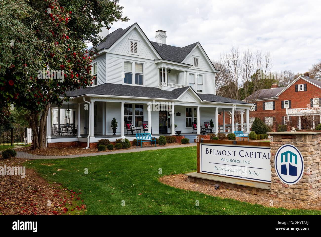 BELMONT, NC, USA-8 MARCH 2022: Elegant, white clapboard home, with wraparound covered porch, now offices of Belmont Capital Advisors, Inc. Stock Photo