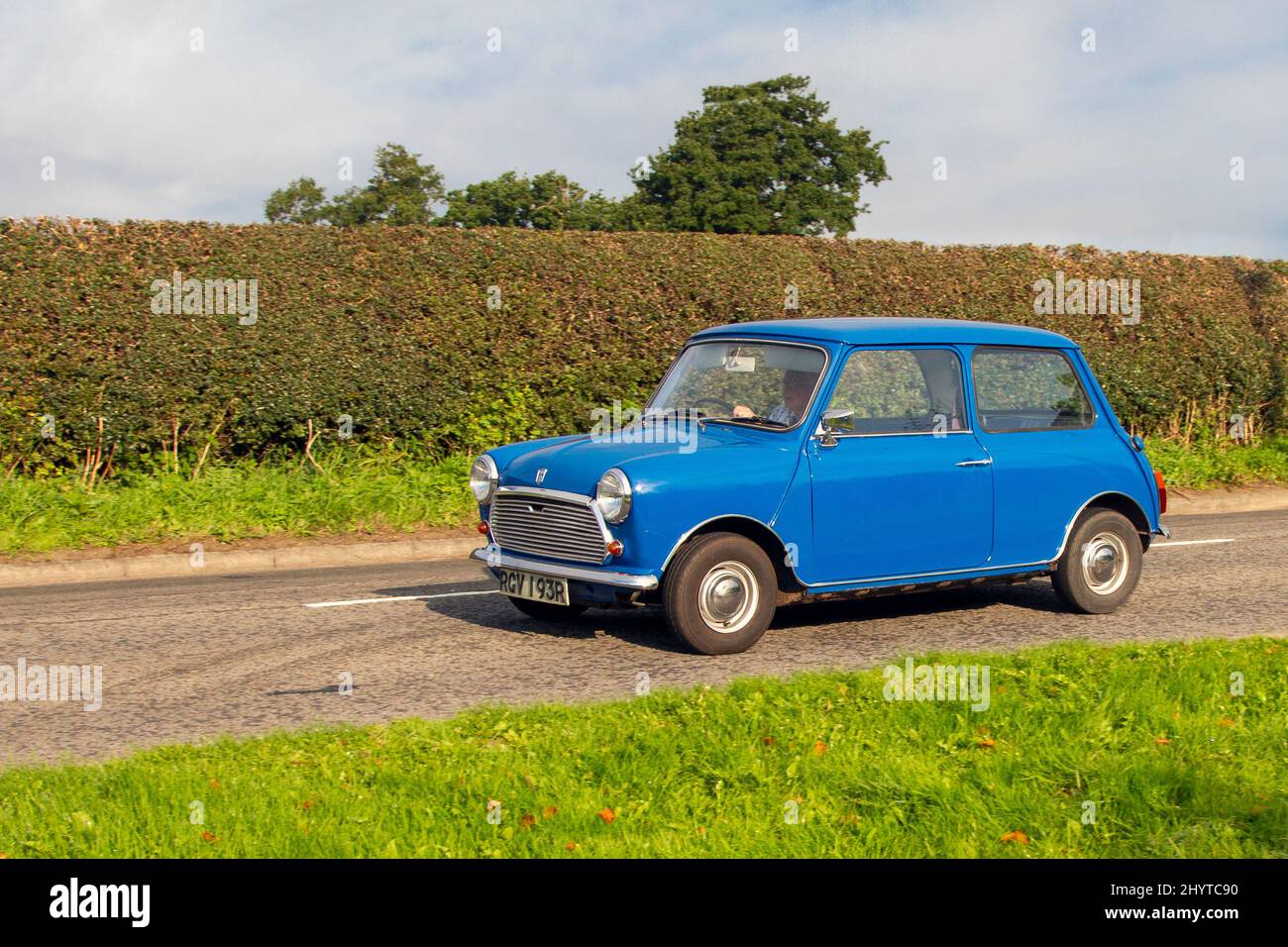 1976 70s seventies British Leyland cars blue Mini 850, 848cc petrol small city car en-route to Capesthorne Hall classic August car show, Cheshire, UK Stock Photo