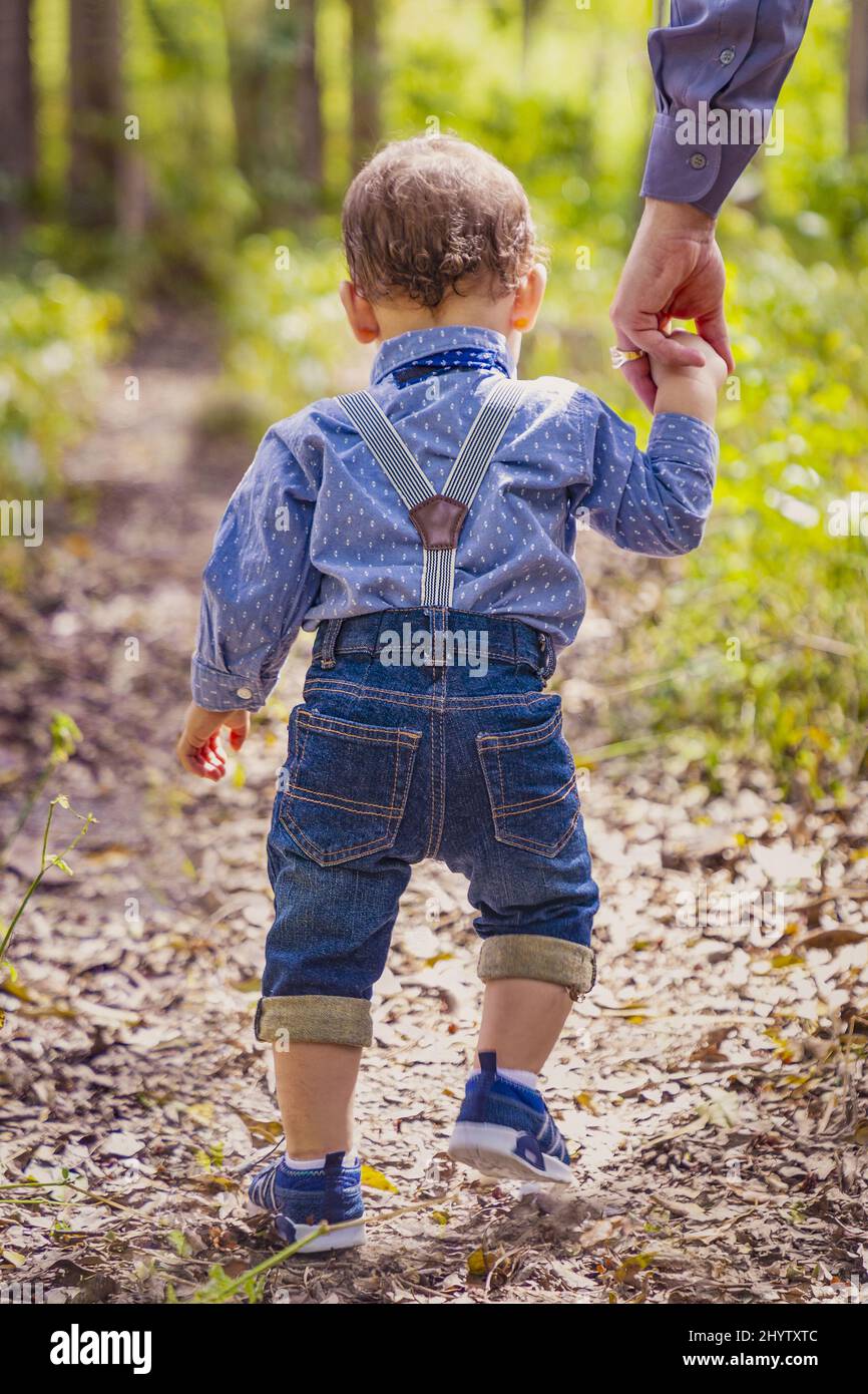 Vertical shot of a boy holding his dad's hand and walking Stock Photo ...
