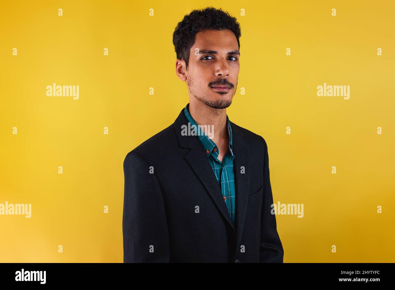 Black man in a suit in the studio isolated on yellow background. Stock Photo