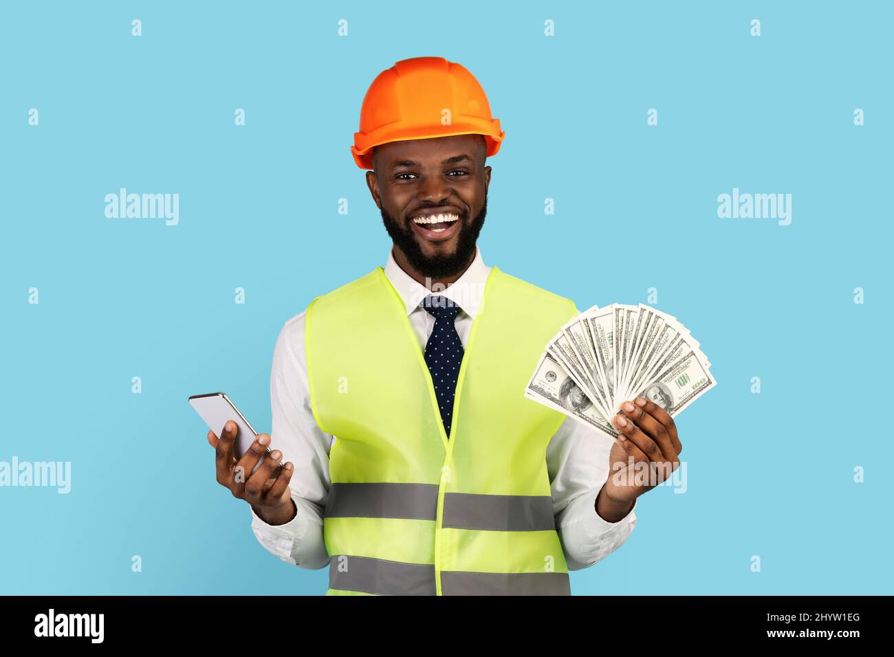 Happy Construction Worker With Money Cash And Smartphone Posing Over