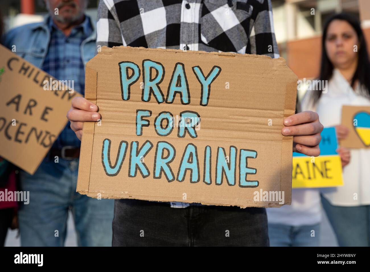 A boy demonstrator shows a cardboard sign in support of the Ukrainian people during an anti-war street protest. Stock Photo