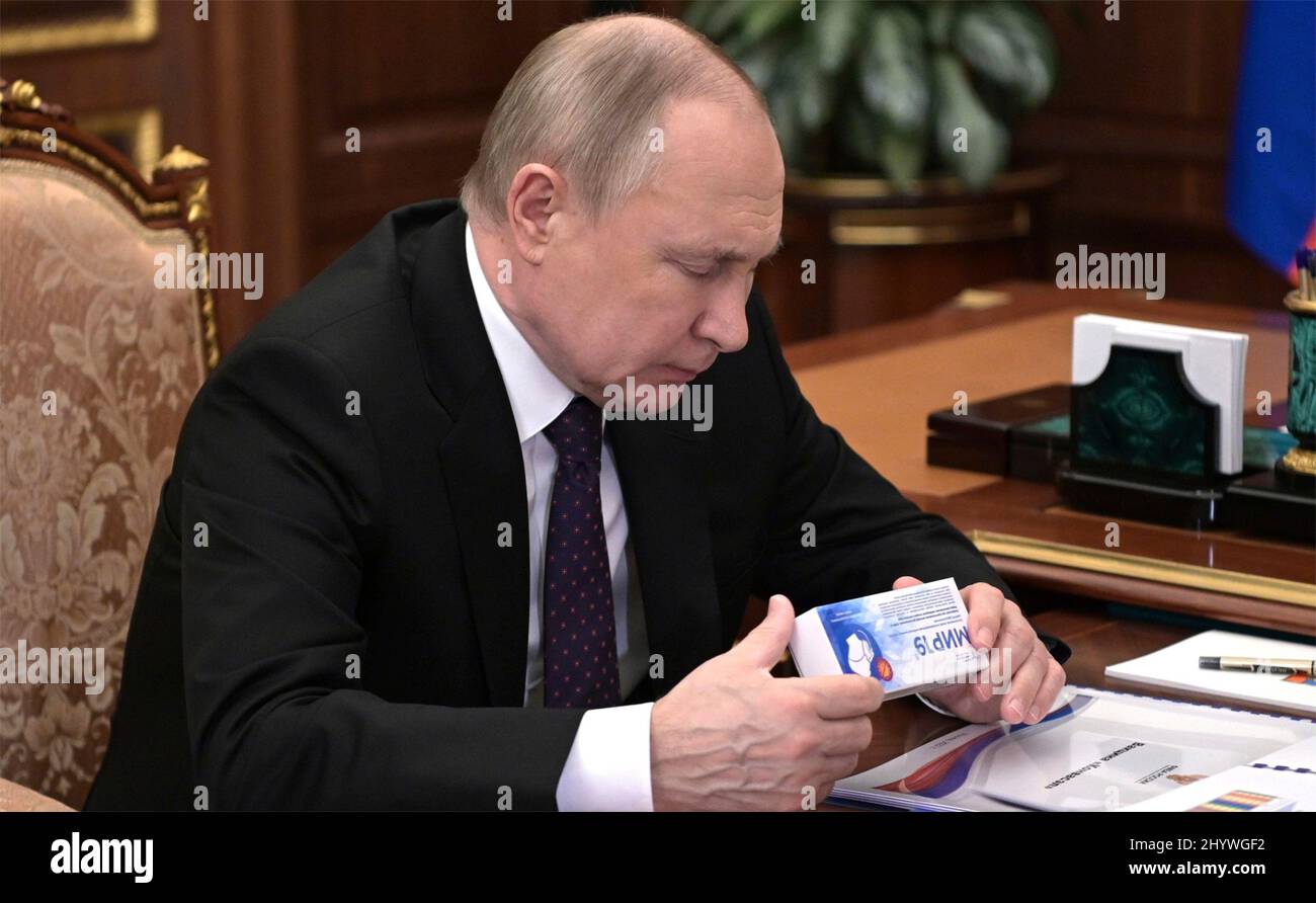 Moscow, Russia. 15th Mar, 2022. Russian President Vladimir Putin examines a  box of the Mir-19 antiviral medication during a face-to-face meeting with  Head of the Federal Medical-Biological Agency Veronika Skvortsova, right, at