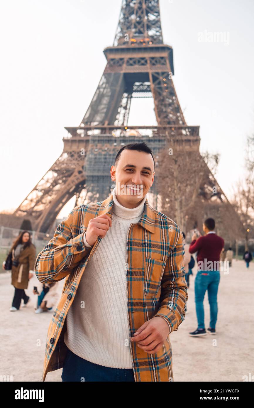 Guy tourist on the background of the Eiffel Tower posing. Male tourist