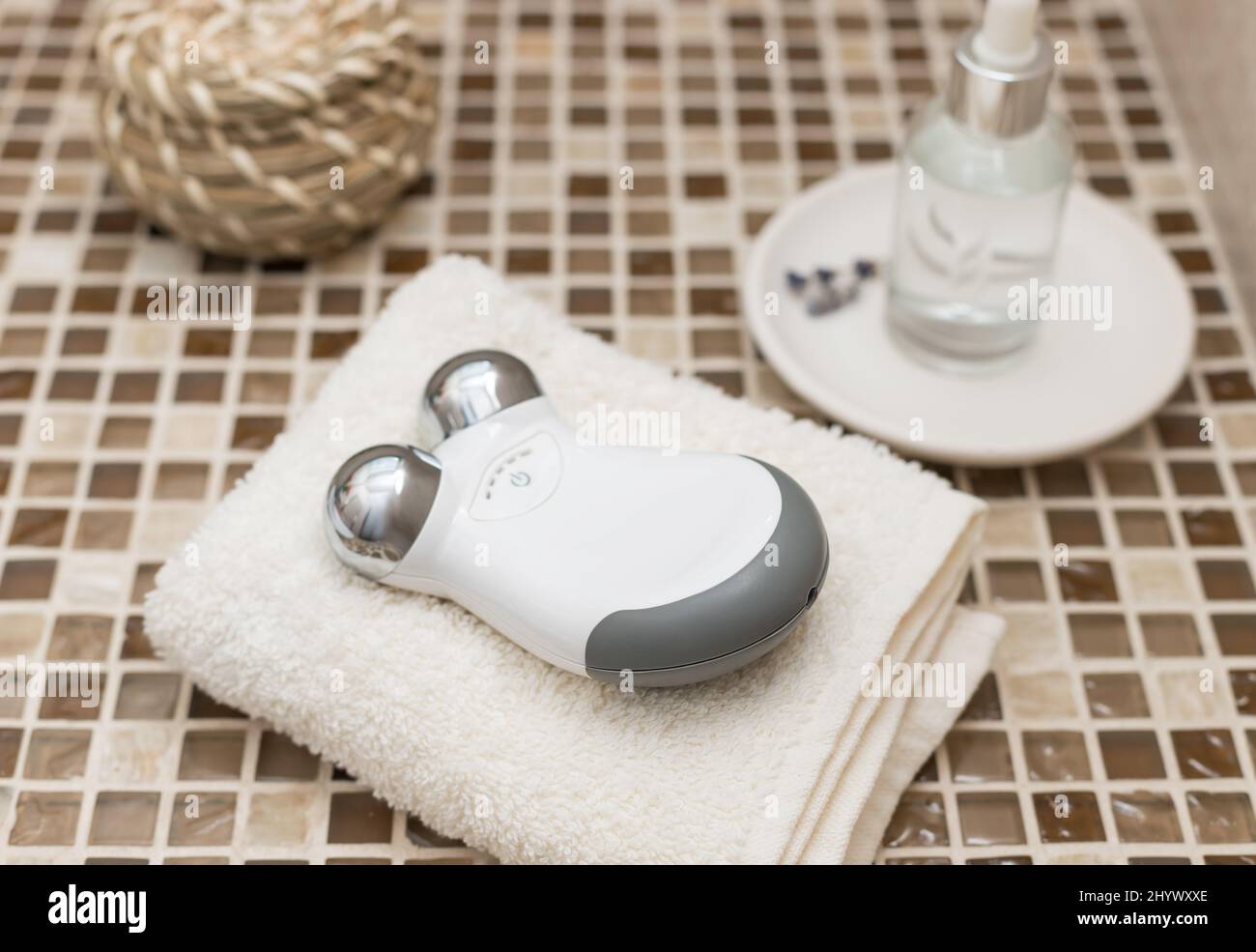 microcurrent facial toning device and beauty serum on countertop Stock