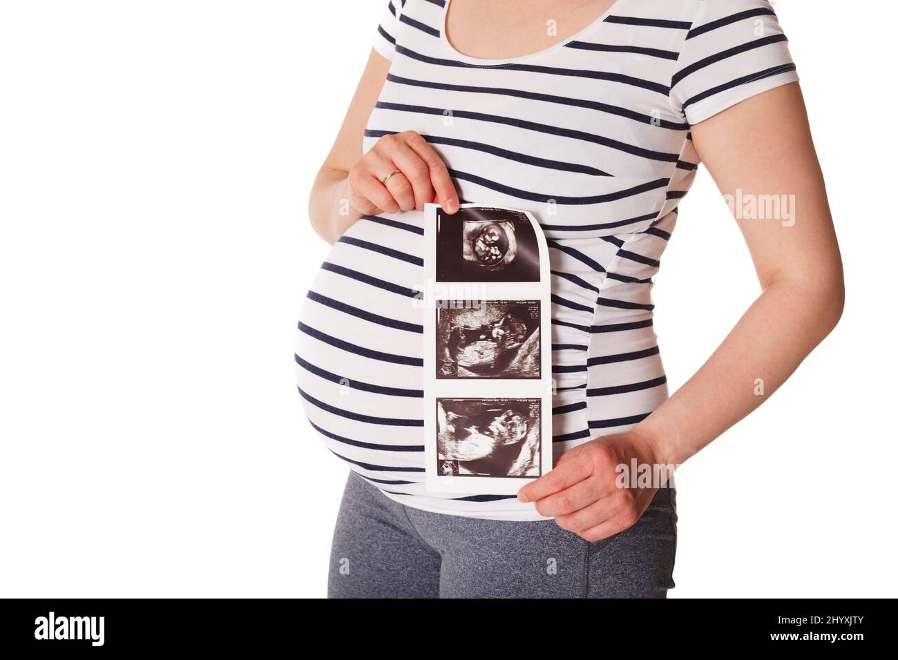 Pregnant woman standing and holding her ultrasound baby scan Stock Photo