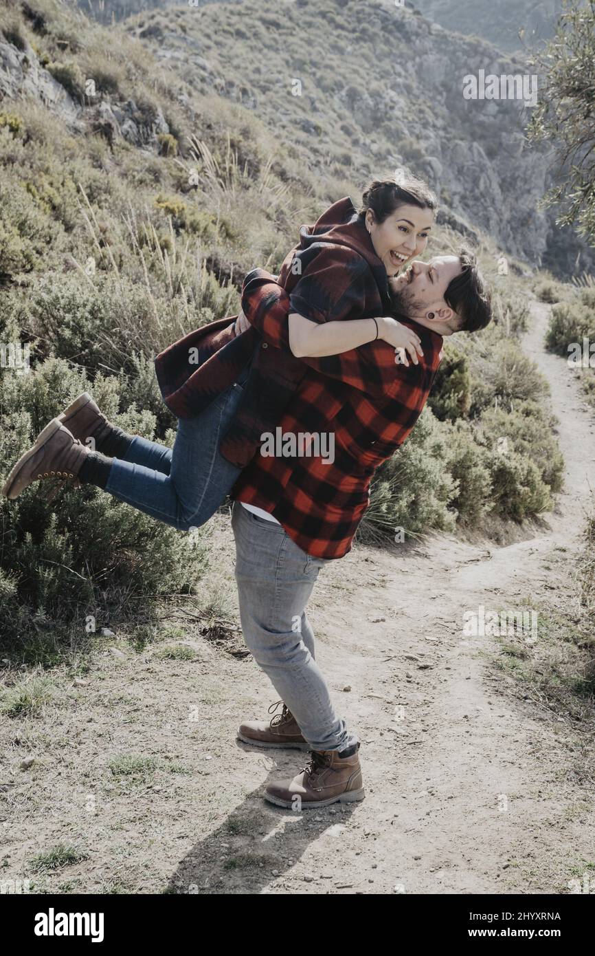 Man hugging his woman on a trail in a forest Stock Photo - Alamy