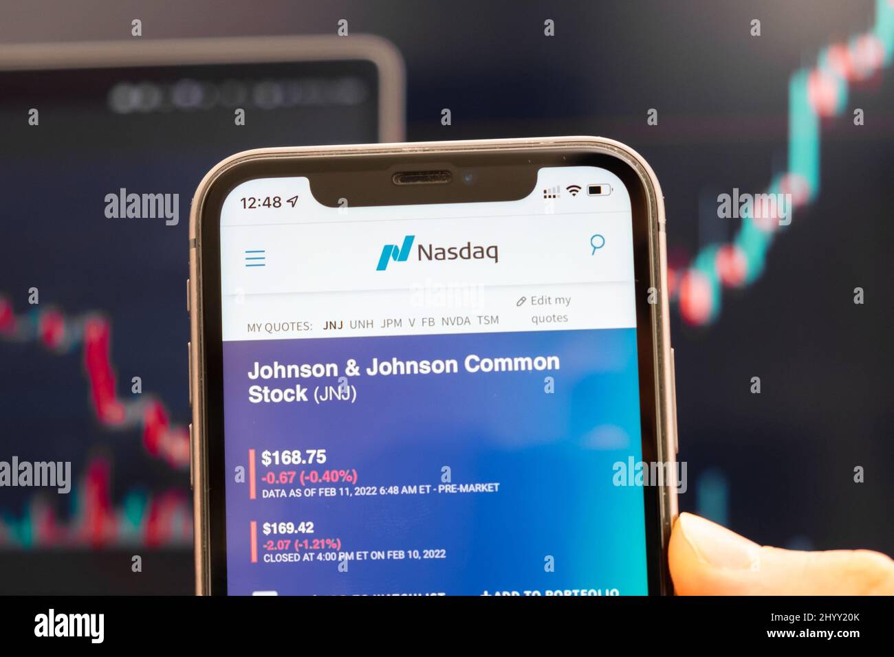 Johnson and Johnson JNJ logo of stock price on the screen of smartphone in mans hand with changing trend on the chart on the background, February 2022, San Francisco, USA. Stock Photo