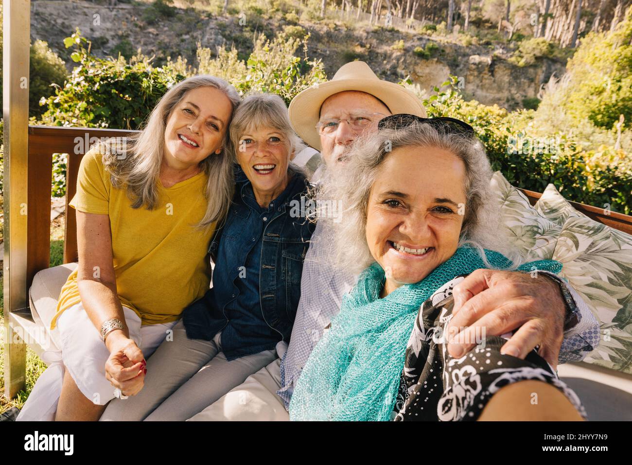 Happy elderly friends taking a selfie together during vacation. Cheerful elderly people enjoying a weekend getaway at a spa resort. Group of senior ci Stock Photo