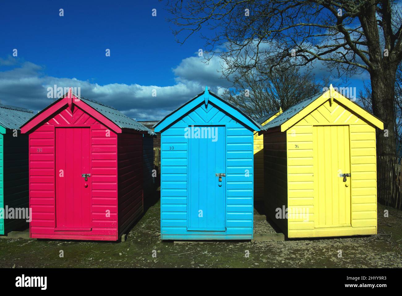 Iconic, old fashioned beach huts. Typical British seaside scene at Abersoch, north Wales on a sunny spring day. Close up view Stock Photo