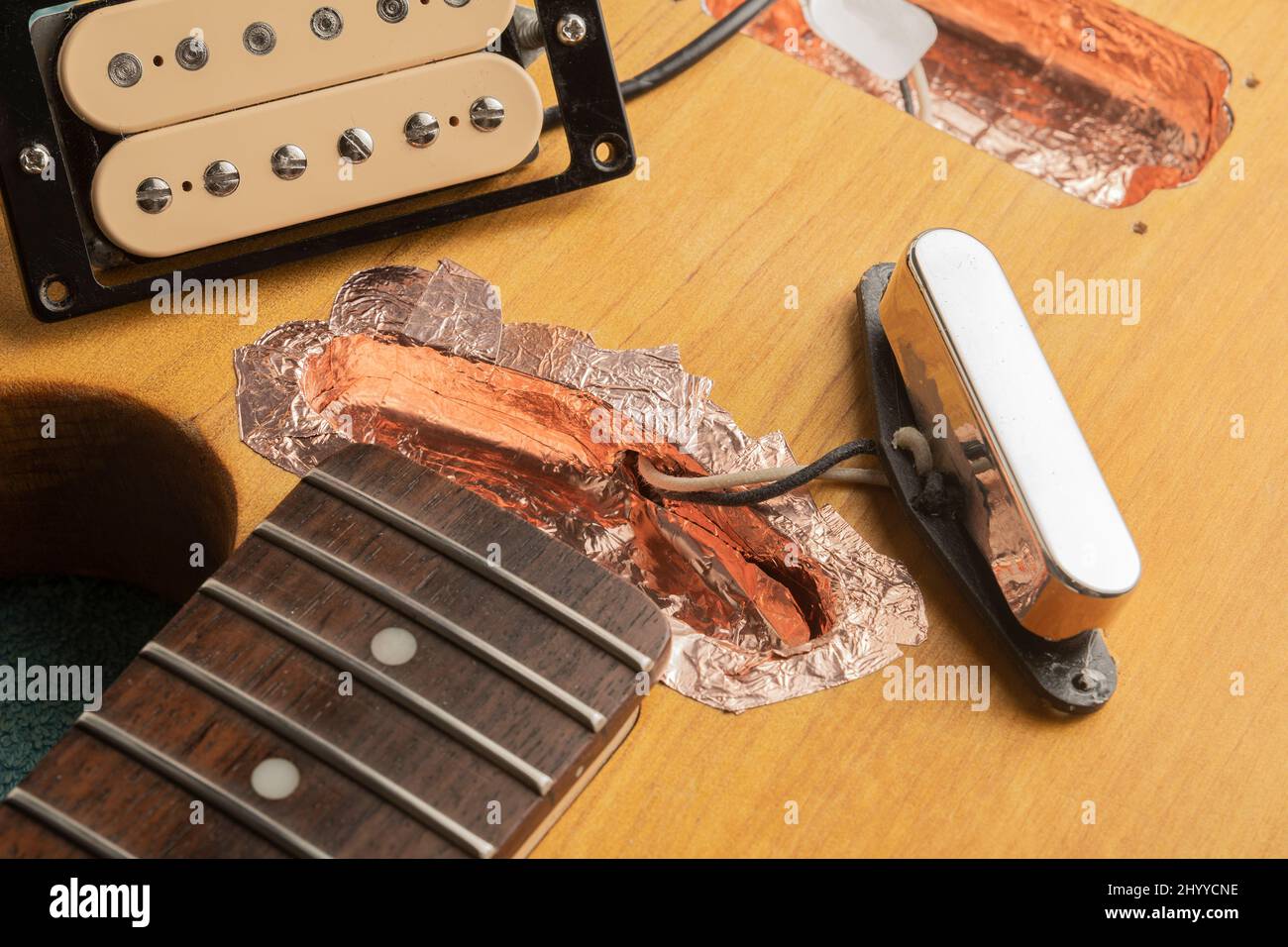 Shielding of the pickup housings of an electric guitar with copper tape Stock Photo