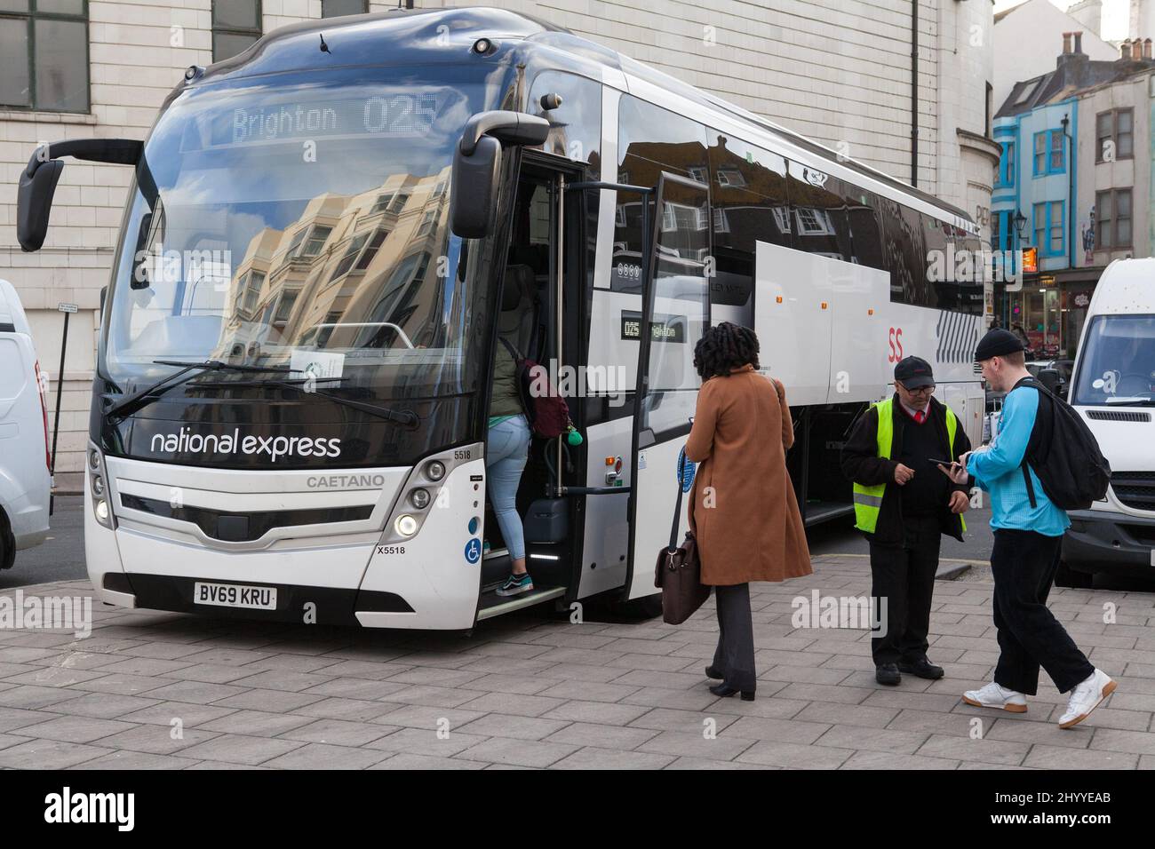 Passengers get their tickets checked before boarding a National Express coach in Brighton Stock Photo