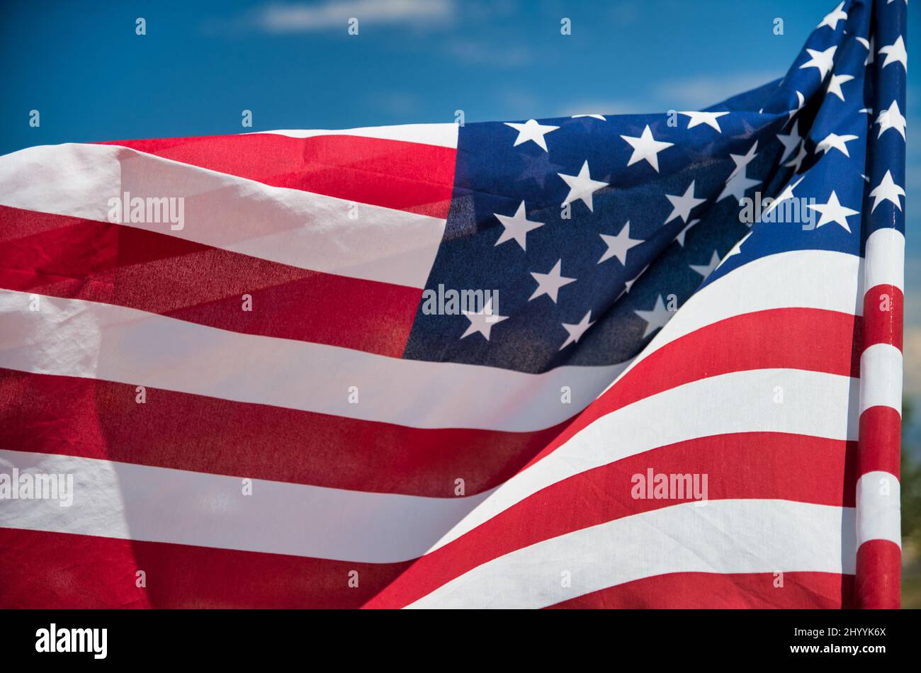 Waving American Flag on blue sky background. Stock Photo