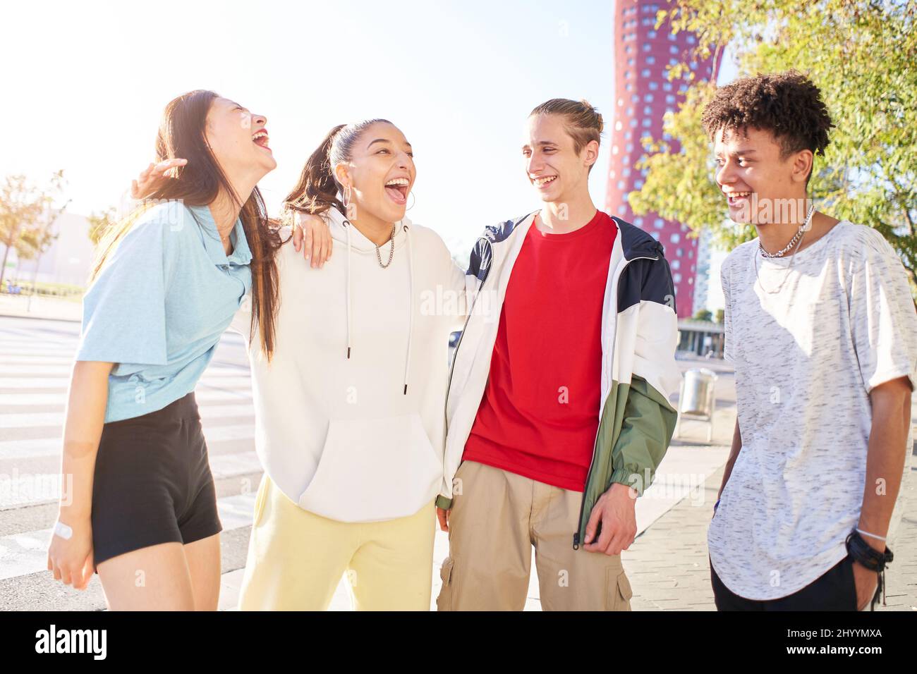 Group of young people having fun together outdoors. Portrait of multiethnic students laughing at the city. Stock Photo