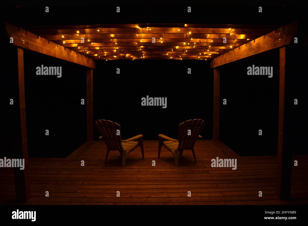 Two wicker chairs on verandah of house at night Stock Photo - Alamy