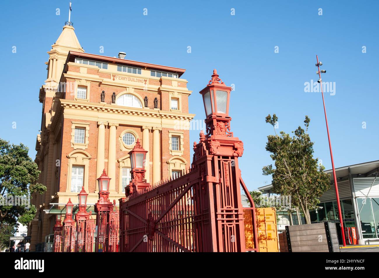 Auckland New Zealand - December 26 2015; Historic Ferry Building downtown in city with red wrought iron fence and lamps Stock Photo