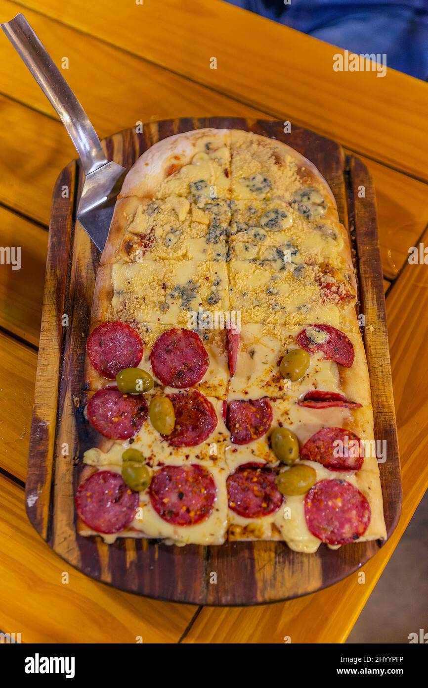 elongated argentine pizza, with salami, olives, and cheeses Stock Photo