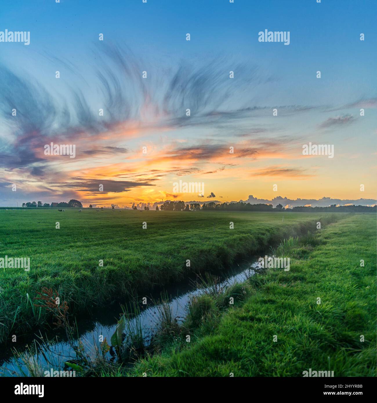 Beautiful view of river flowing through grassy fields at sunset Stock ...