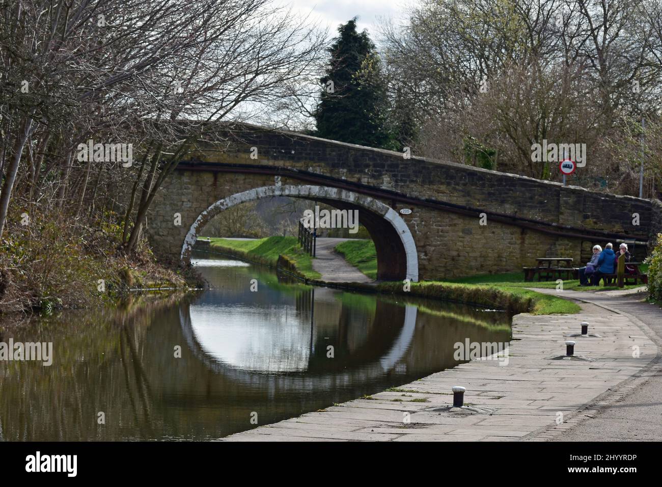 People sitting by canal bridge, Leeds and Liverpool canal, Dowley gap, Bingley Stock Photo