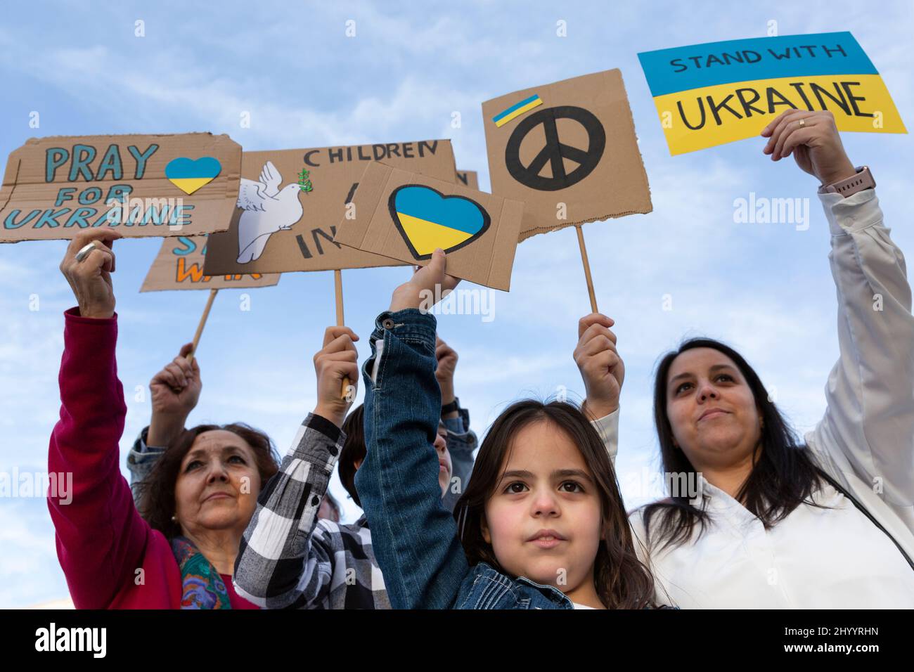 Group of people with raised banners demonstrating against the war in Ukraine. Activism and human rights movement. Stock Photo