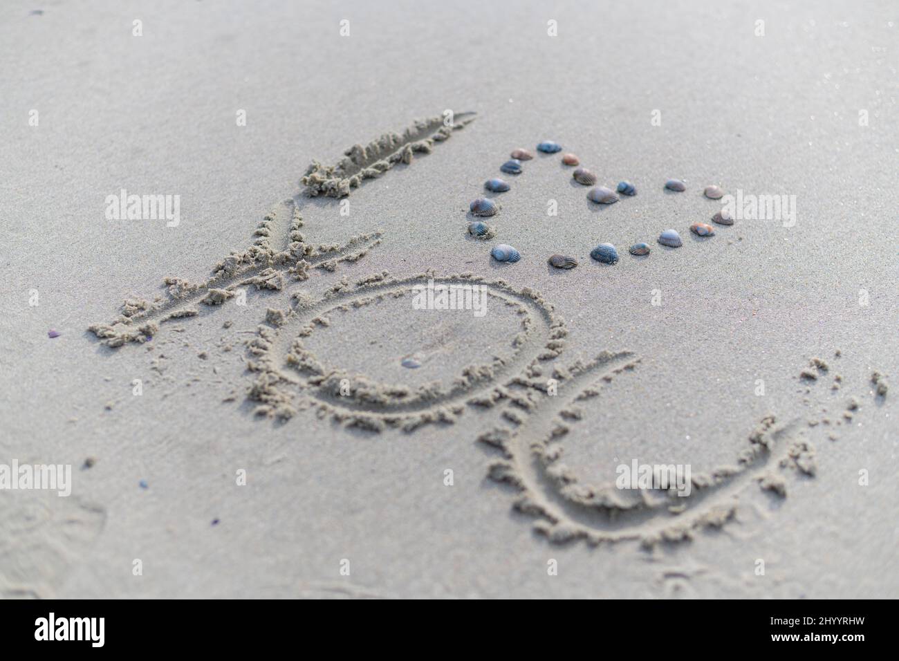 A  heart with shells and i love you was written in the sand Stock Photo