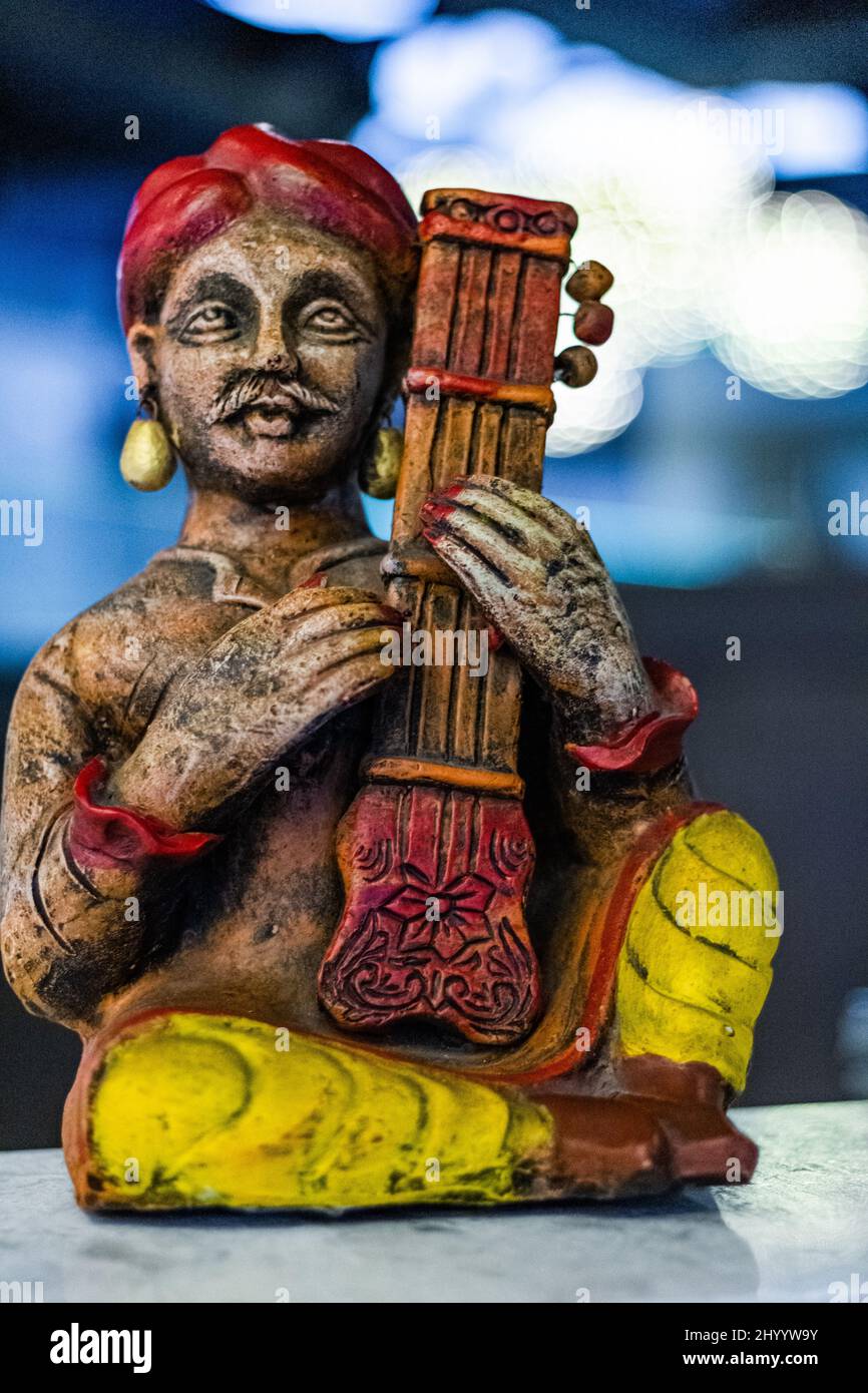Vertical shot of the small Indian musical performer statue at the