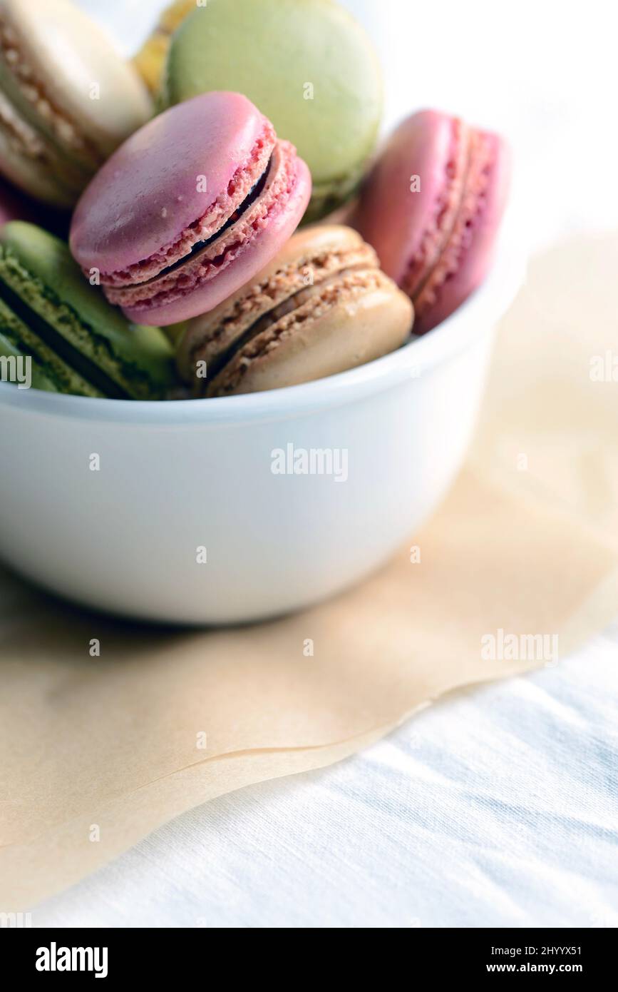 French macarons in a bowl on parchment paper in natural light Stock