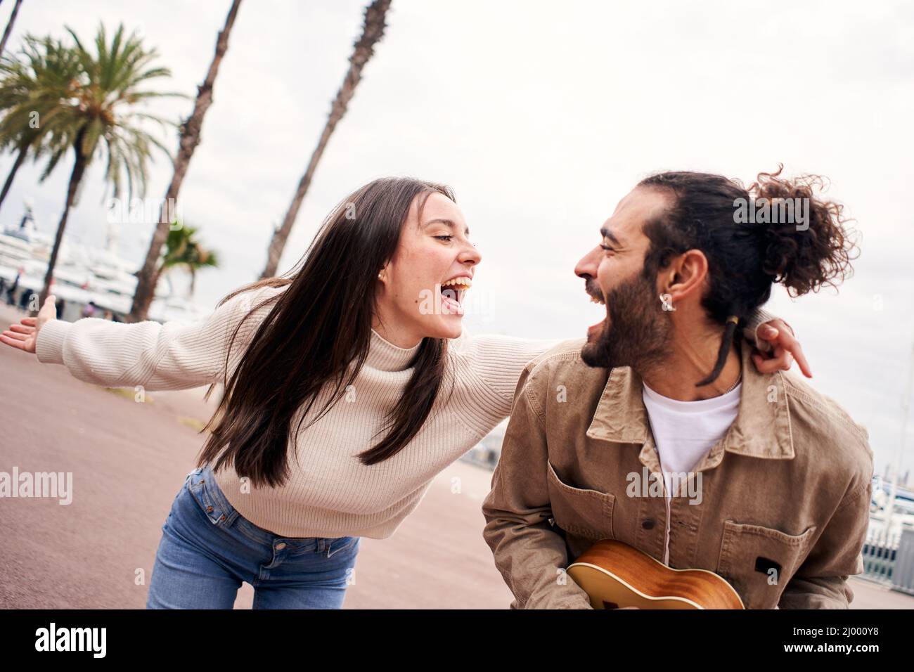 Happy couple having fun singing and dancing outdoors Stock Photo