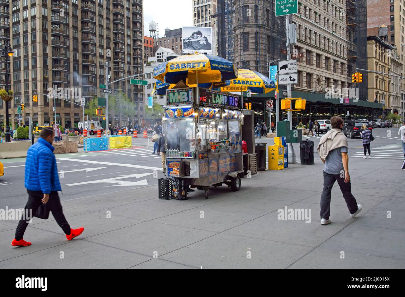 New York, NY, USA - Mar 15, 2022: Vendor near Flatiron Building with steam coming from cart as meat products are kept hot Stock Photo