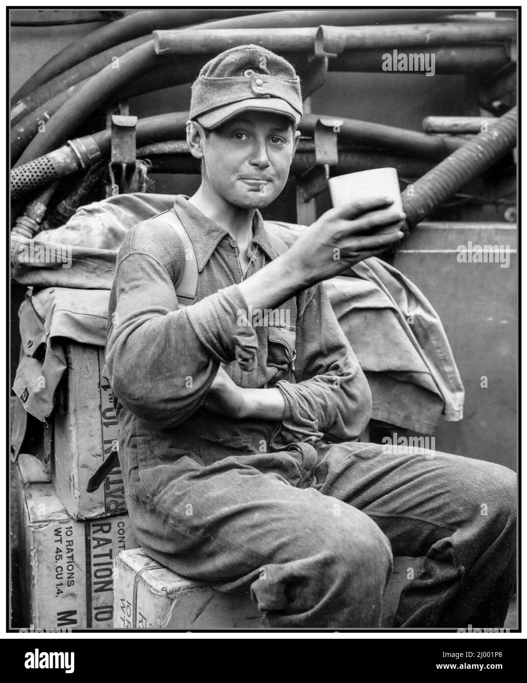 WW2 D-Day invasion a captured 13-year-old German Hitler-Jugend Hitler Youth soldier drinks coffee aboard a small Allied landing craft (LCI), departing, For him happy the war has ended well Northern France World War II Second World War Stock Photo