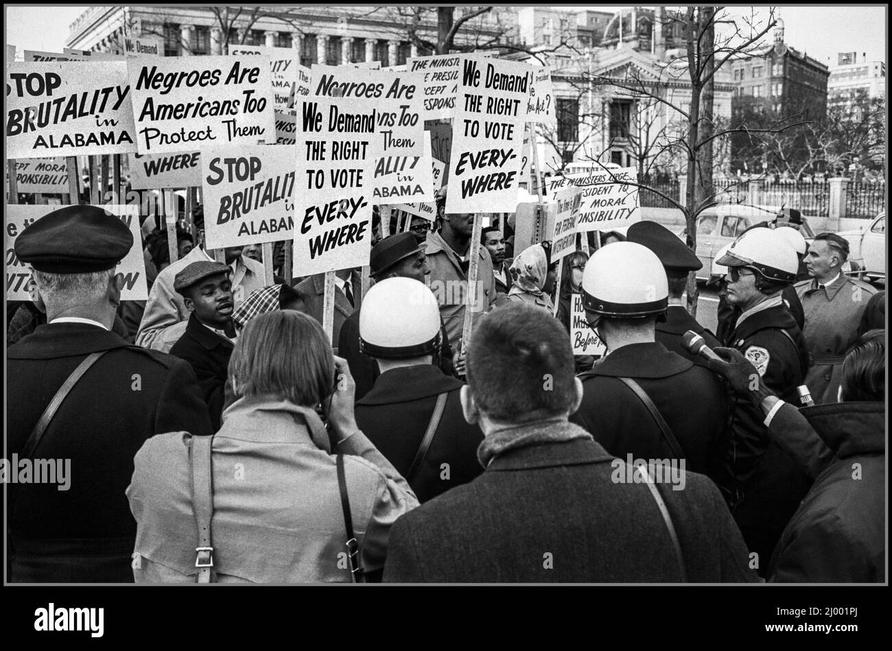 Racial Civil Rights 1960s African American demonstrators outside the White House, with signs 'We demand the right to vote, everywhere' and signs protesting police brutality against civil rights demonstrators in Selma (Washington D.C. 1965) Stock Photo