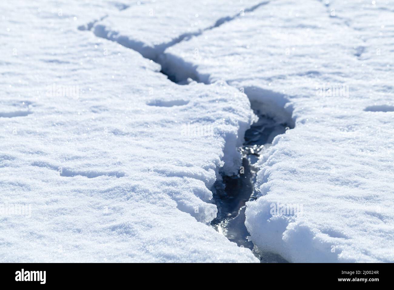 Broken ice under snow on a frozen lake surface, natural winter