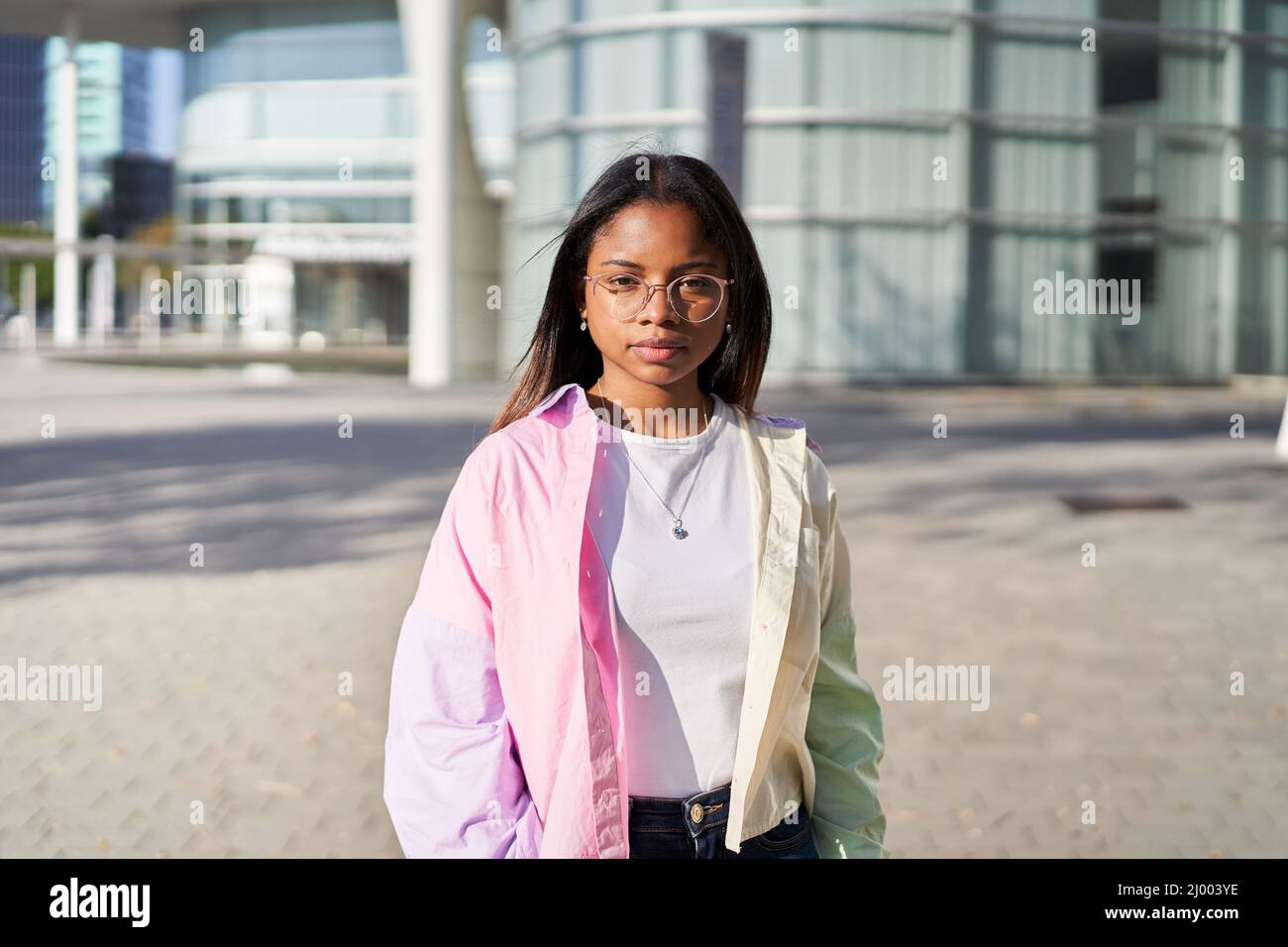 Portrait of a girl looking at the camera serious. Confident young African American woman standing outdoors. Stock Photo