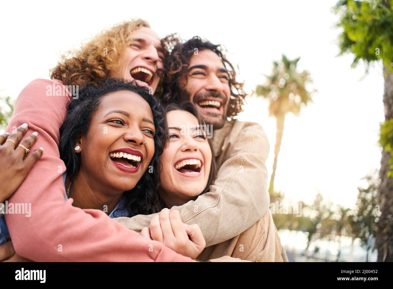 Embrace People Laughing. Young group of Friends Outdoors. Youth Culture and City Lifestyle Stock Photo