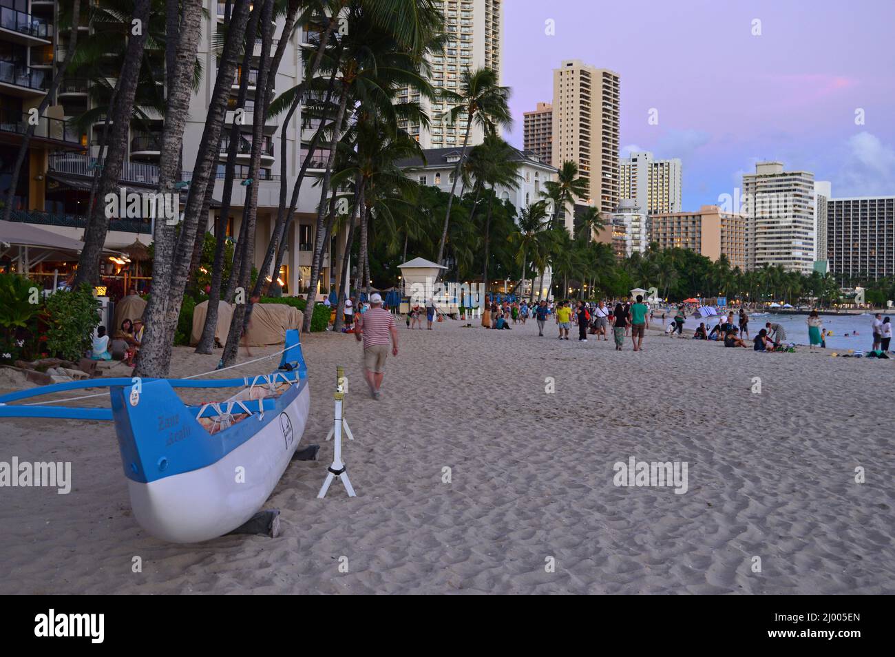 Stragglers remain on Waikiki Beach after the sun has set Stock Photo