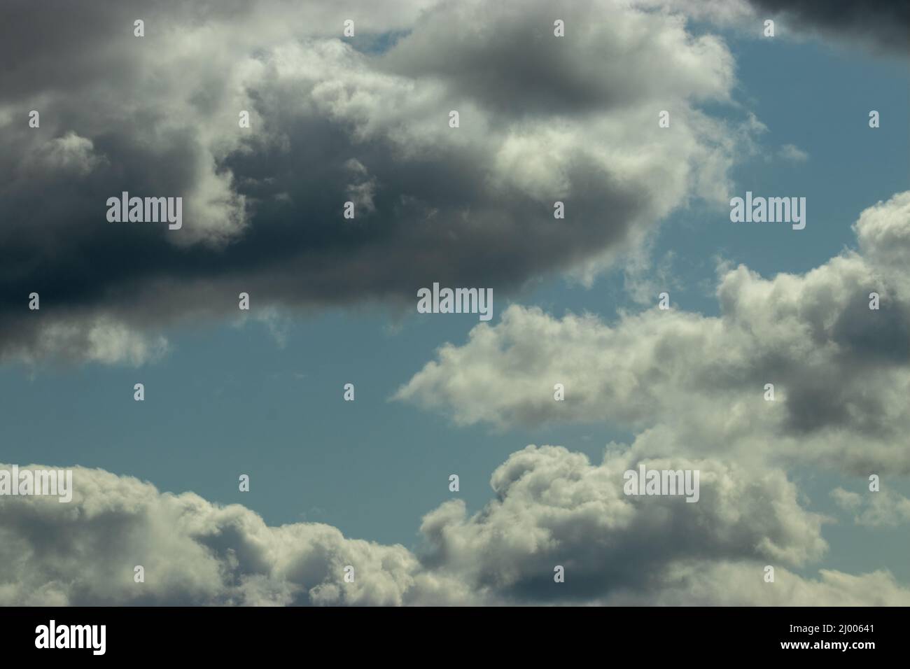 puffy storm clouds gathering against blue sky Stock Photo