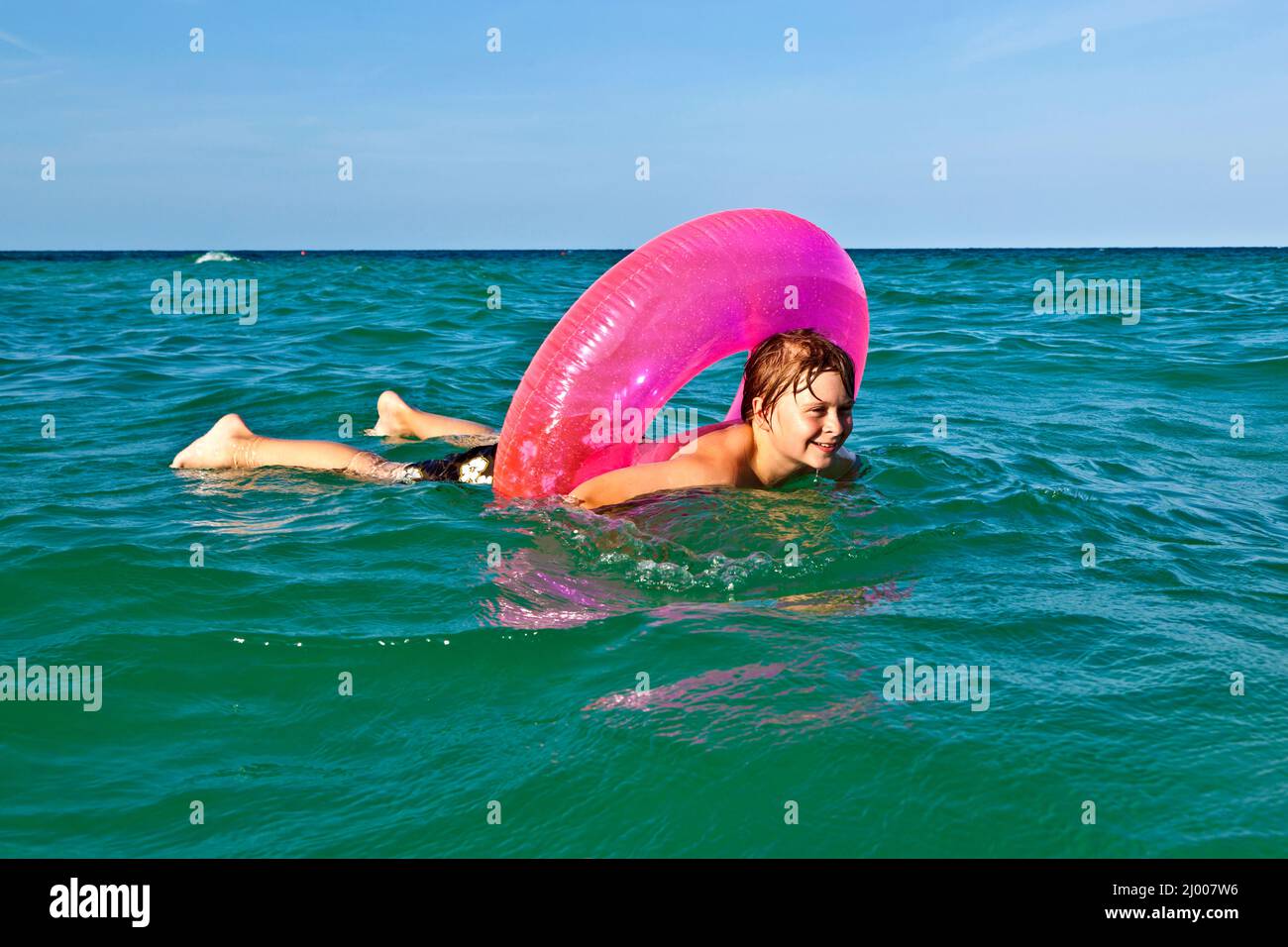 happy boy in a swim ring has fun in the ocean Stock Photo Alamy