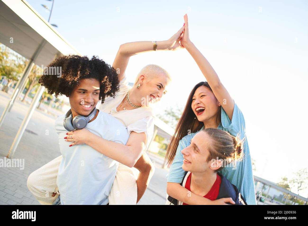 Friends piggyback having fun together. Multiracial young people stacking hands. Stock Photo