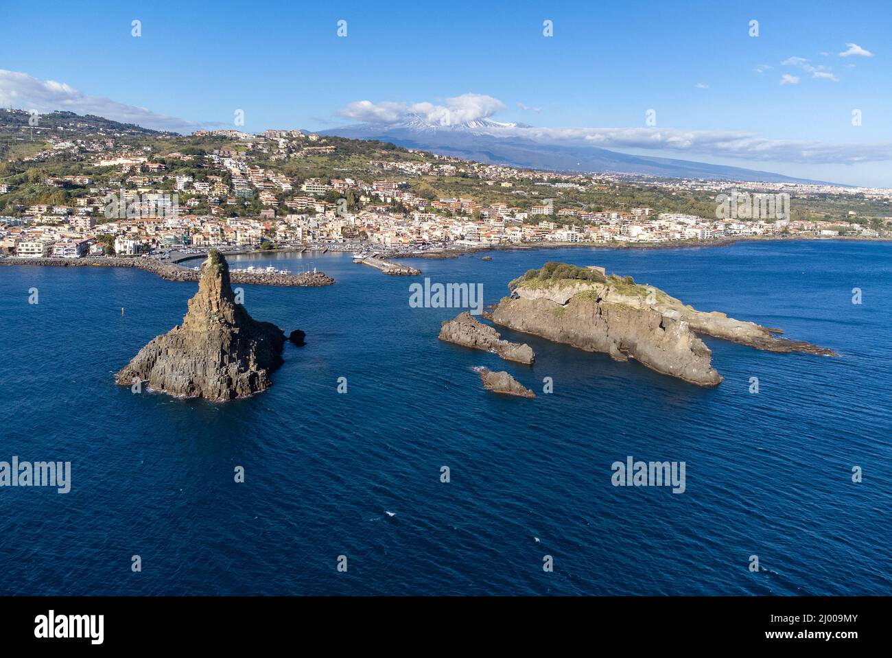 Aerial View. Panoramic drone image of the stacks of Acitrezza with mount Etna in the background - Travel destination, Catania, Sicily, Italy Stock Photo