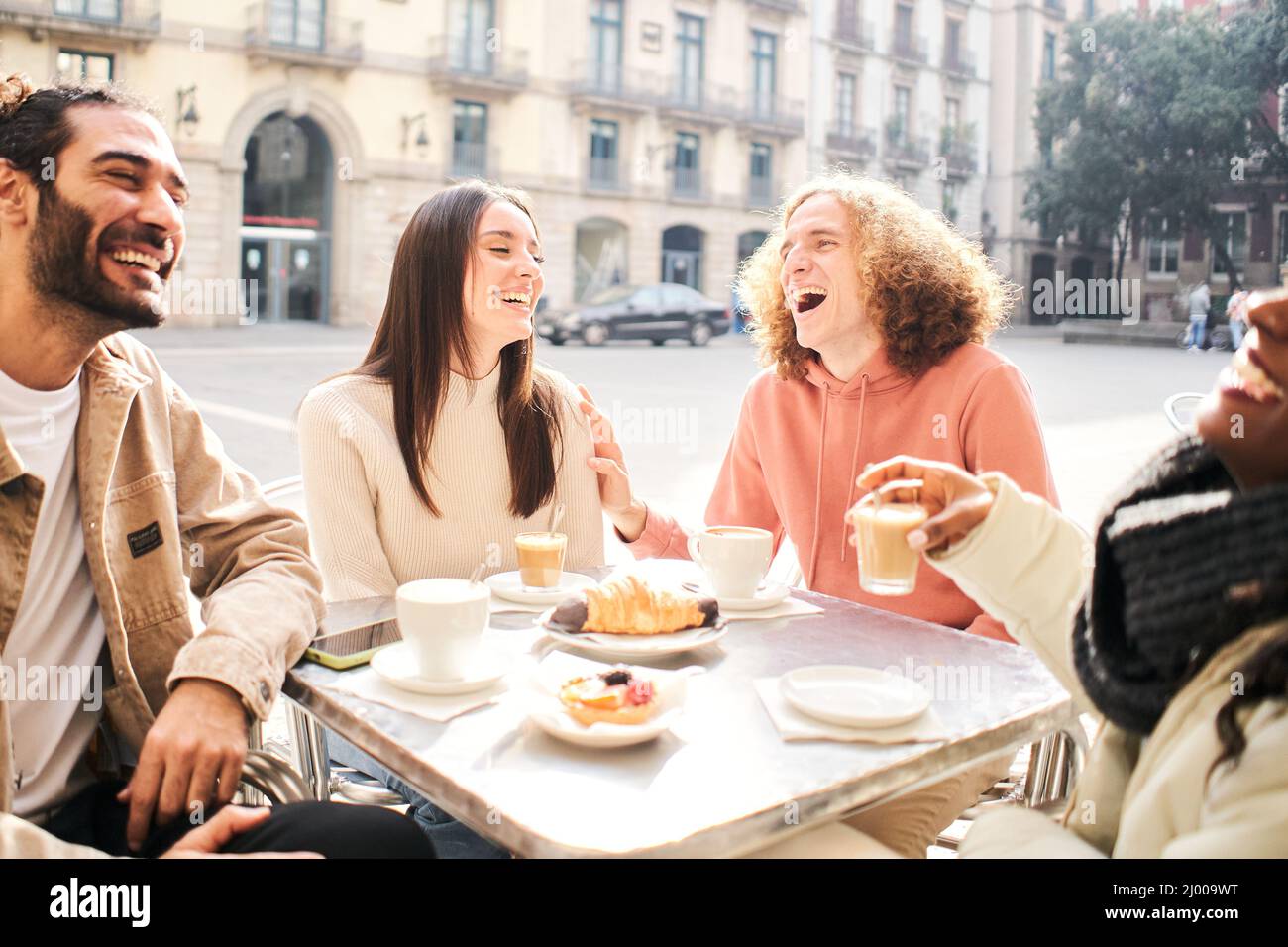 Young people dining having breakfast - Happy friends laughing together talking coffee on happy hour at cafe bar restaurant. Food, beverage and happy Stock Photo